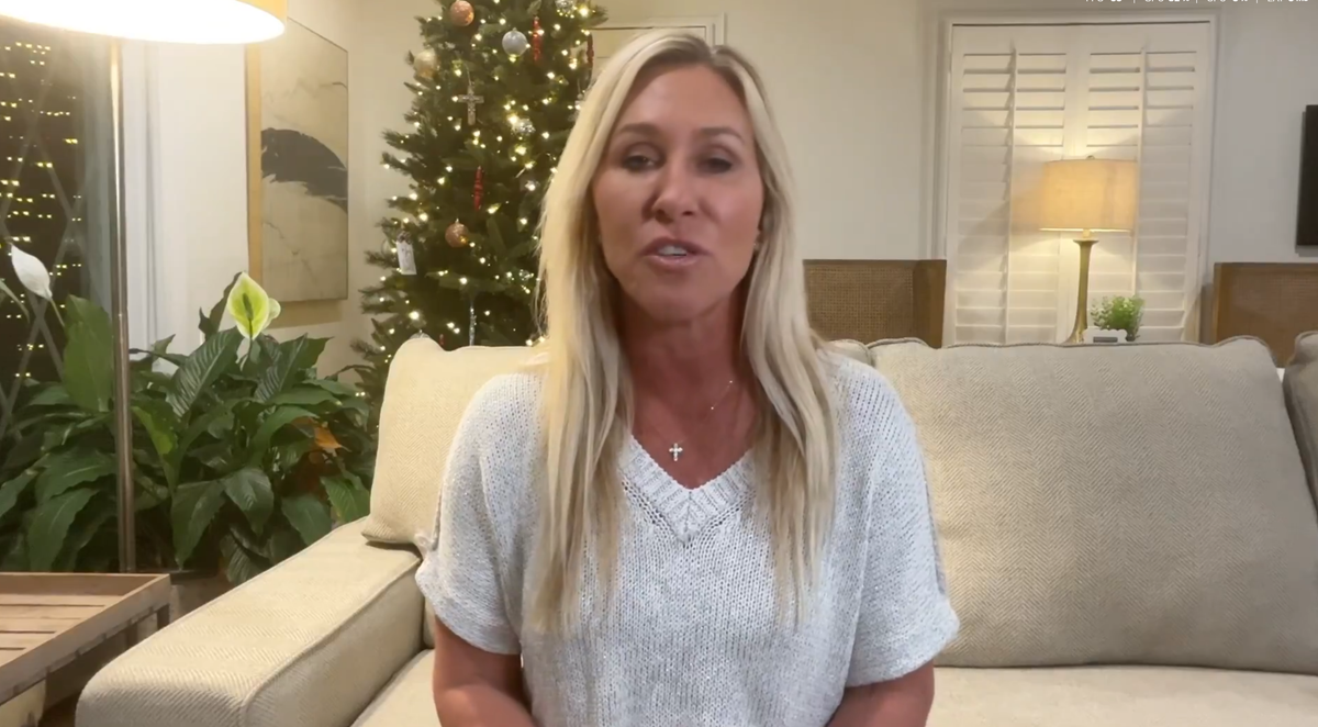 Marjorie Taylor Greene sitting in her living room giving her resignation on camera.